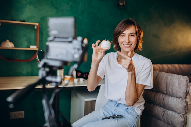 Mulher beleza vlogger filmando vlog sobre cremes