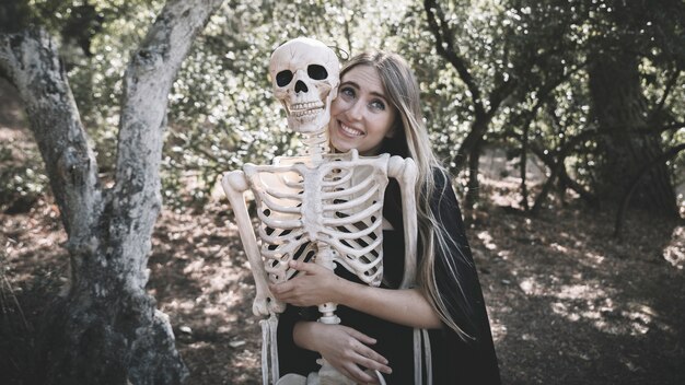 Mulher bonita, abraçando, atrás de, esqueleto