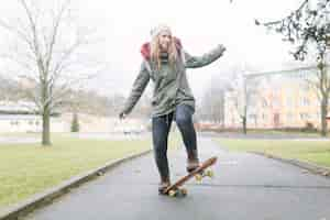 Foto grátis mulher bonita andando de skate no caminho