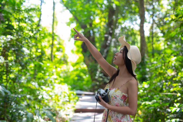 mulher bonita, apontando o dedo para algo no céu no jardim