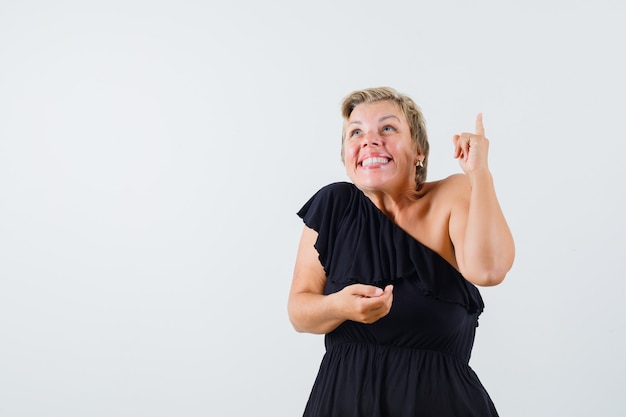 Mulher bonita apontando para cima com blusa preta