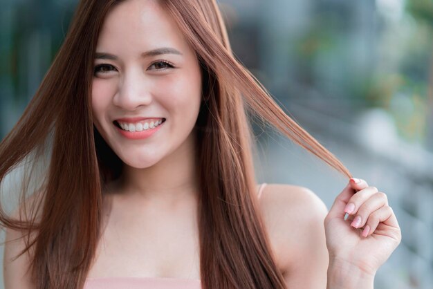 Mulher bonita asiática de cabelo comprido retrato de moda vestido rosa sorriso com felicidade e alegre