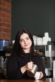 Mulher bonita barista fazendo cappuccino