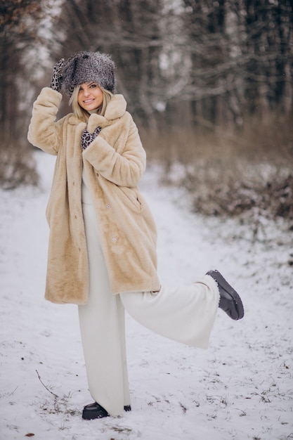 Mulher bonita caminhando em um parque cheio de neve