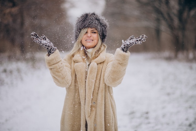 Mulher bonita caminhando em um parque cheio de neve