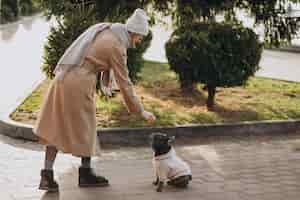 Foto grátis mulher bonita com buldogue francês andando no parque