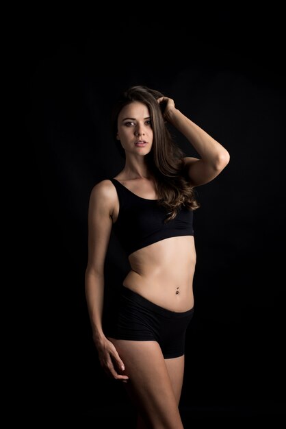 Mulher bonita com corpo saudável em fundo preto