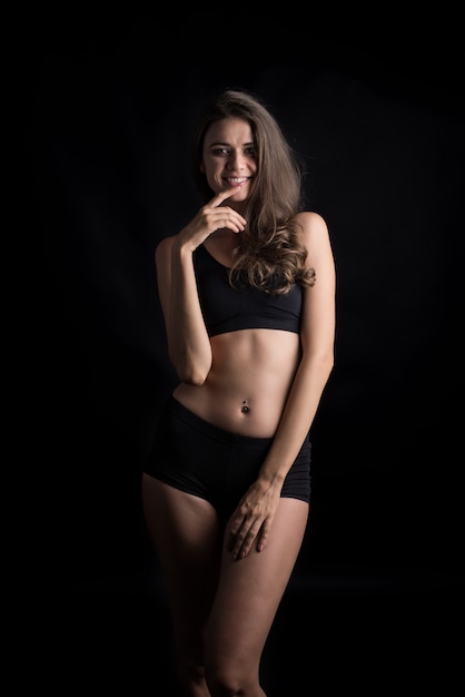 Mulher bonita com corpo saudável em fundo preto