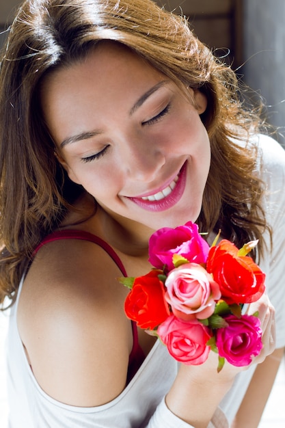 Mulher bonita com flores em casa