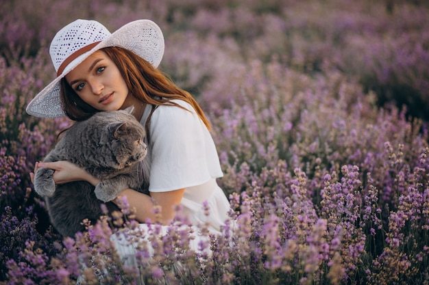 Mulher bonita com gato em um campo de lavanda