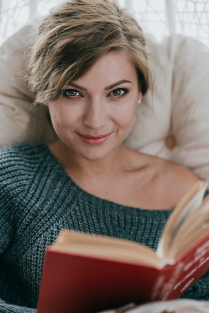 Foto grátis mulher bonita com livro olhando para a câmera