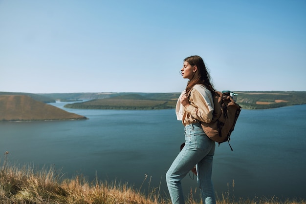 Mulher bonita com mochila na colina perto do rio dniester