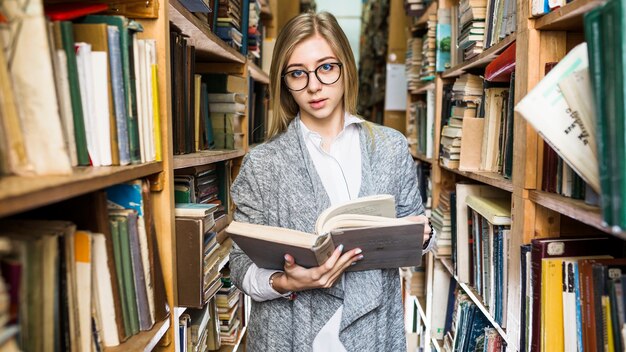 Mulher bonita com o livro aberto, olhando para a câmera