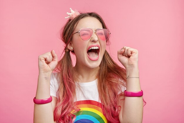 Mulher bonita com óculos de sol rosa da moda