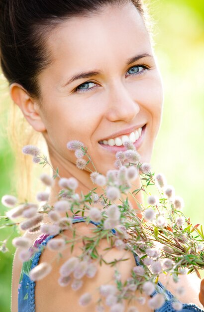 Mulher bonita com planta de campo nas mãos