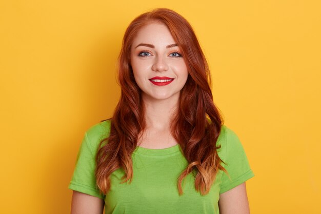 Mulher bonita com rosto sorridente natural com lábios vermelhos, vestindo camiseta verde