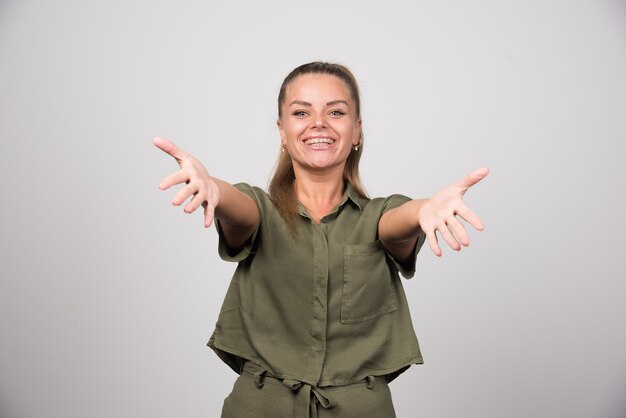 Mulher bonita com roupa verde, oferecendo abraços.