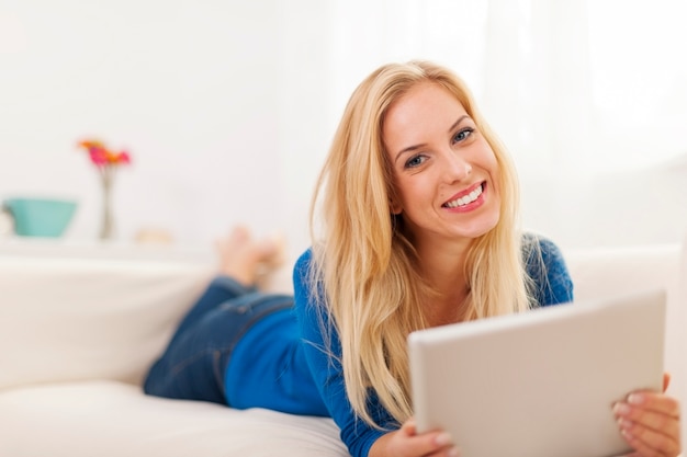 Mulher bonita com tablet digital contemporâneo em casa