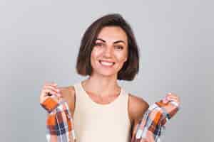 Foto grátis mulher bonita com top e camisa xadrez na parede cinza com maquiagem, sorriso confiante e positivo, emoções felizes