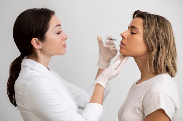 Mulher bonita de tiro médio recebendo preenchimento labial