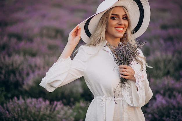 Mulher bonita de vestido branco em um campo de lavanda