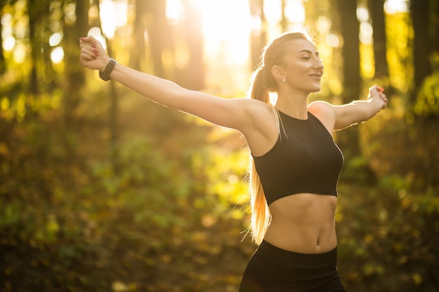 Foto grátis mulher bonita e esportista fazendo exercícios de ioga no parque