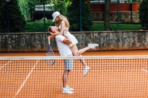 Mulher bonita e homem bonito, depois, estão jogando tênis.