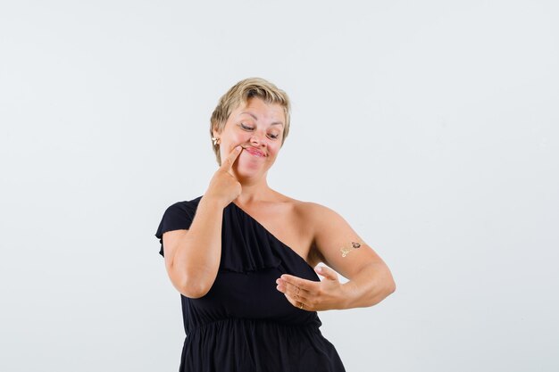 Mulher bonita em blusa preta posando olhando para um caderno e olhando para o foco