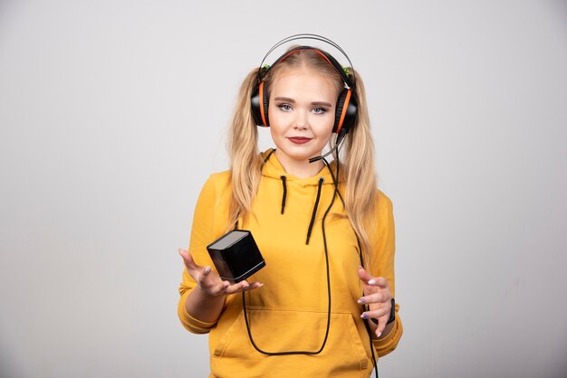 Mulher bonita em fones de ouvido, posando com relógio.