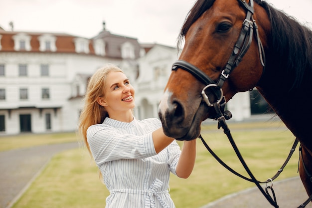 Mulher bonita em pé com um cavalo