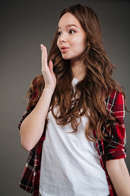 Mulher bonita em pé de camisa xadrez e mandando beijo do ar