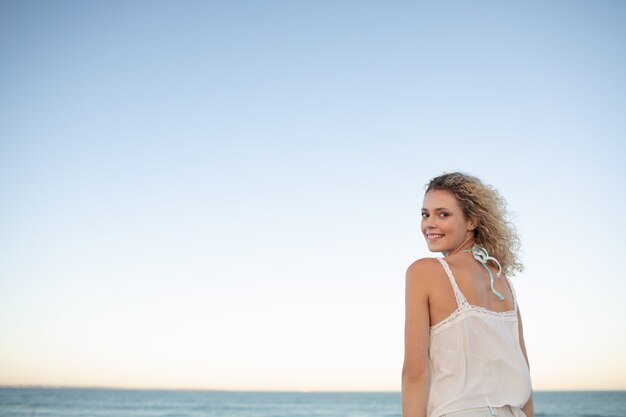 Mulher bonita em pé na praia