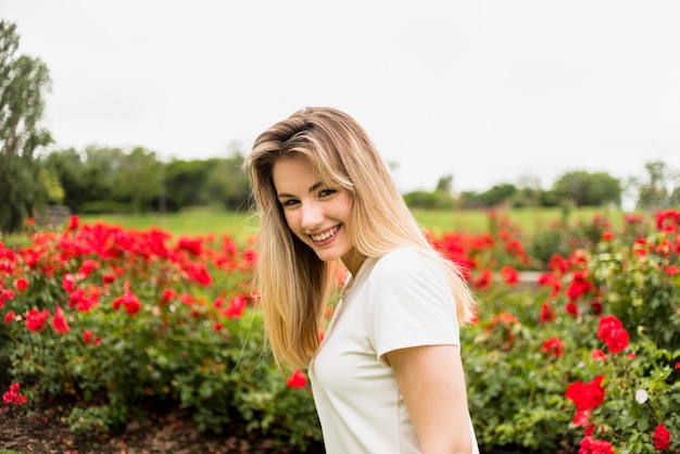 Mulher bonita em pé no jardim de flores