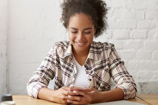 Mulher bonita em um café em seu smartphone