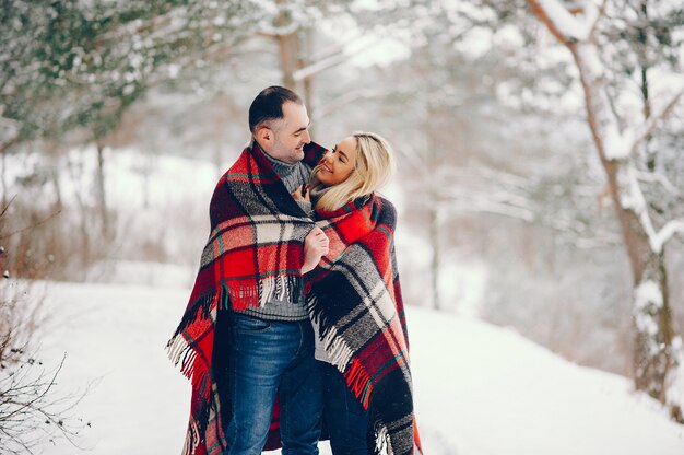 Mulher bonita em um parque de inverno com o marido