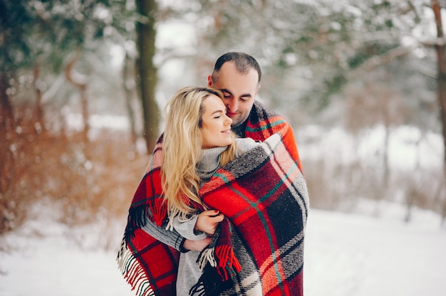 Mulher bonita em um parque de inverno com o marido