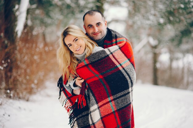 Mulher bonita em um parque de inverno com o marido