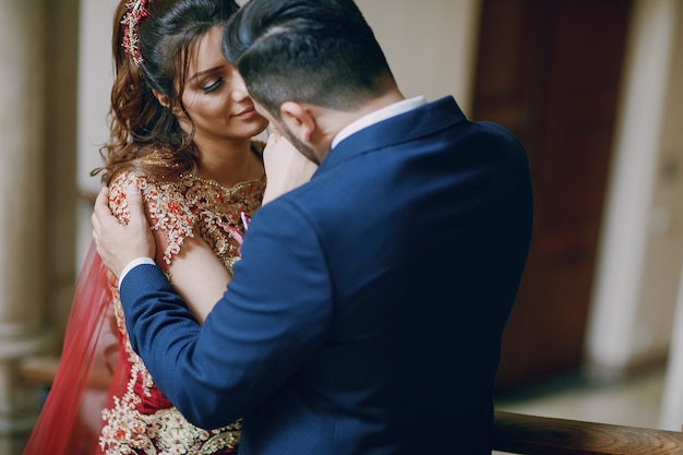 Mulher bonita em um vestido vermelho longo anda pela cidade com o marido