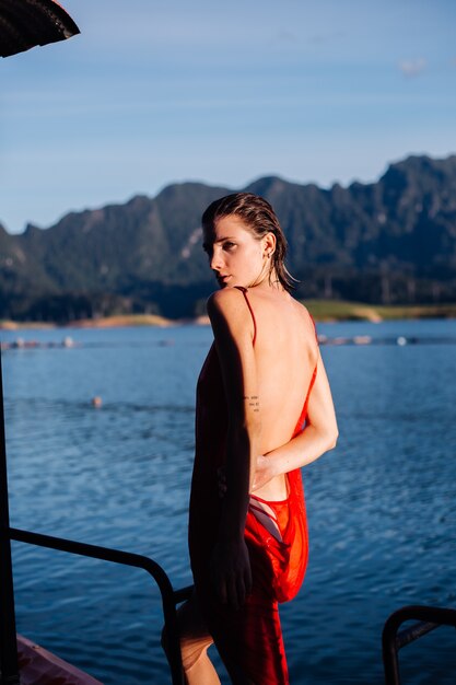 Mulher bonita em vestido de férias, lago e montanhas no fundo