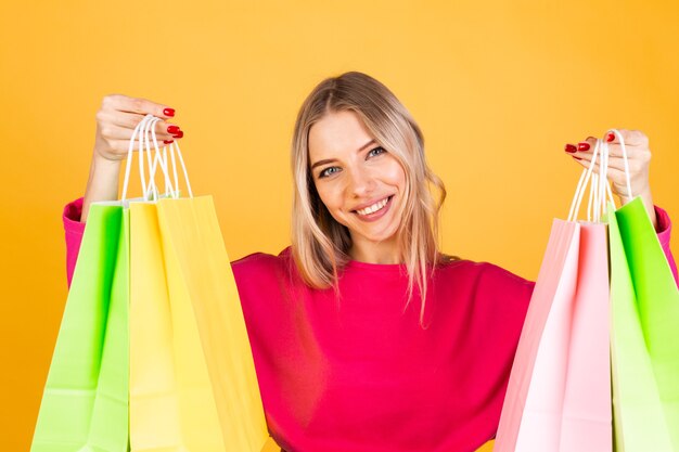 Mulher bonita europeia com blusa rosa na parede amarela