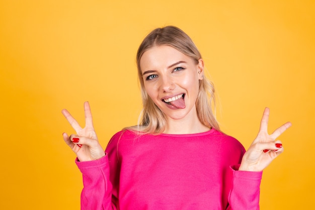 Mulher bonita europeia com blusa rosa na parede amarela