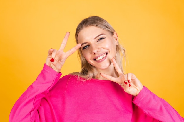 Mulher bonita europeia com blusa rosa na parede amarela