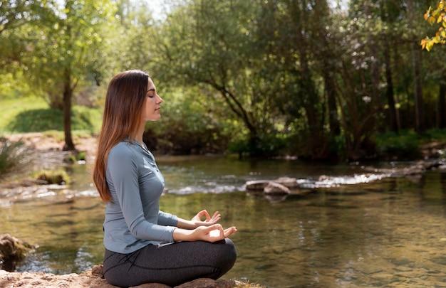 Mulher bonita meditando na natureza