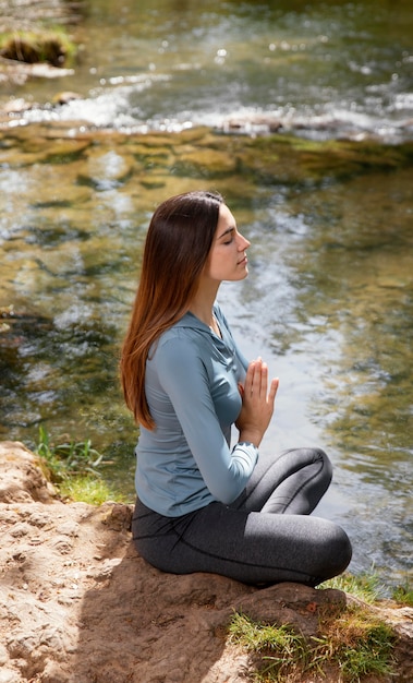 Foto grátis mulher bonita meditando na natureza