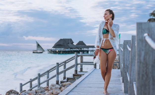 Mulher bonita no desgaste da nadada pelo oceano