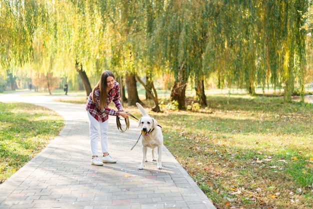 Mulher bonita no parque com seu cachorro