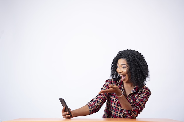 Mulher bonita olhando para o telefone surpresa e animada