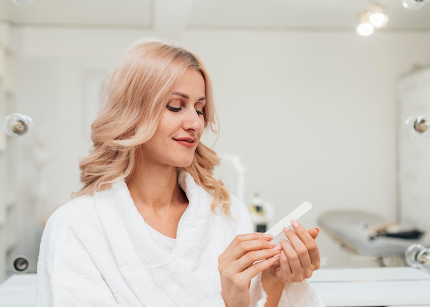 Foto grátis mulher bonita olhando para sua manicure saudável