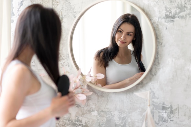 A Menina Bonita Olha Em Um Espelho Em Um Banheiro Foto de Stock - Imagem de  cara, adulto: 13967092