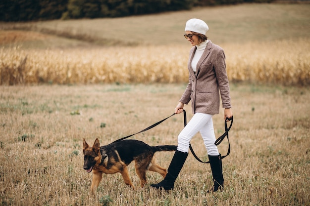 Mulher bonita, passeando com seu cachorro em um campo